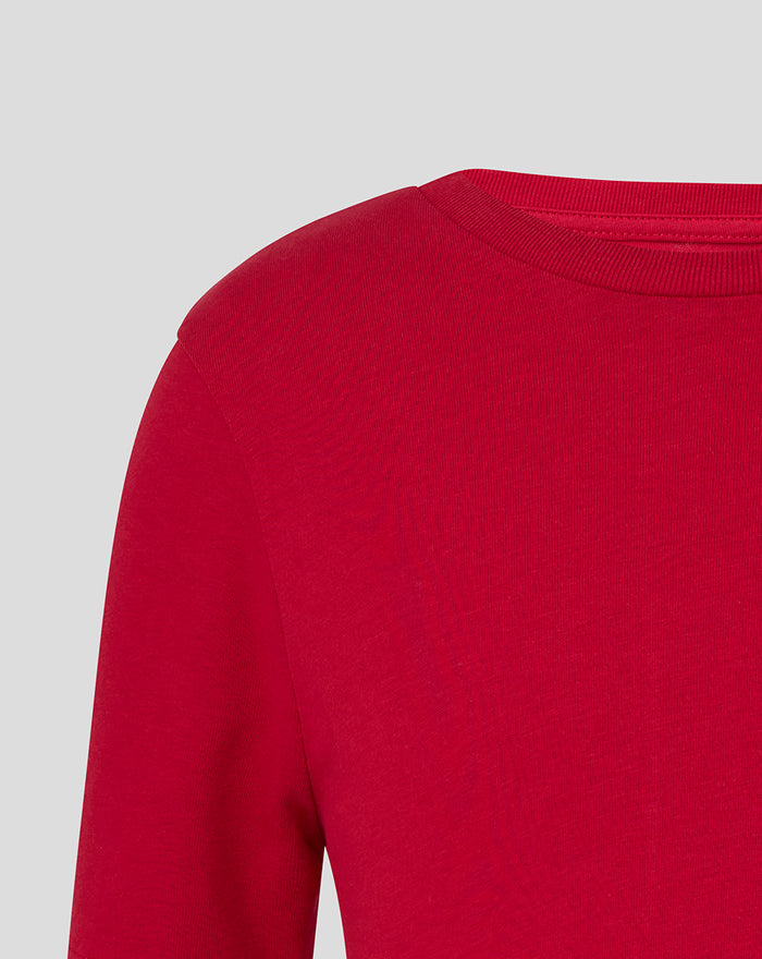 Shoulder and neckline close up of a red junior Crest tee.