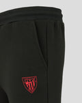 Close-up of the red crest logo on black jogger fabric