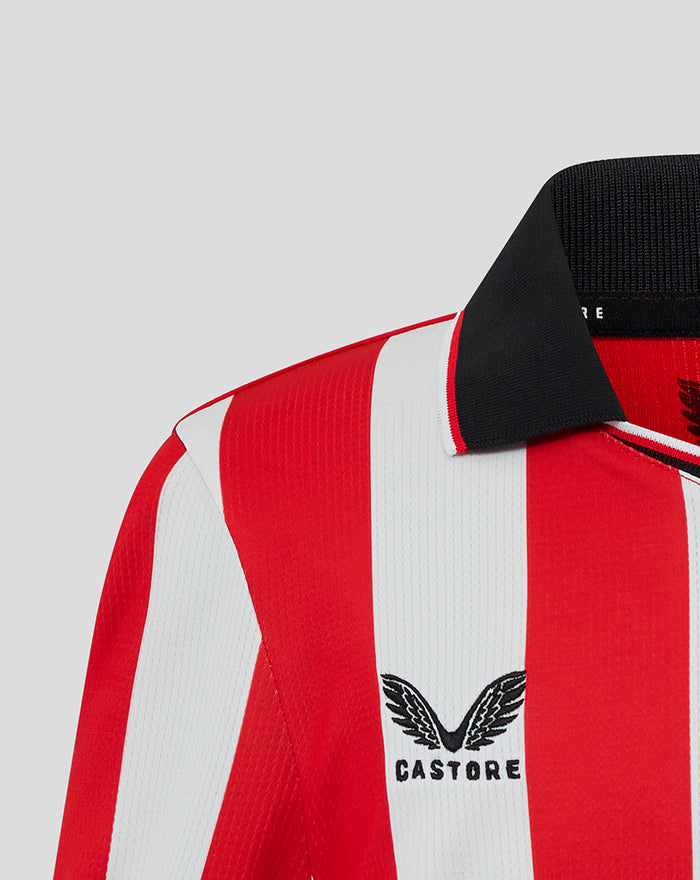 Shoulder detail of red and white striped shirt with Castore branding near the collar and Athletic Club crest on the chest