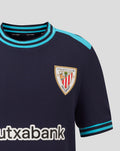 Junior Athletic Club Away shirt close up showing crest on left chest and teal collar trim.