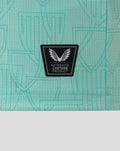 Close-up of black Castore authentic product patch on turquoise fabric.