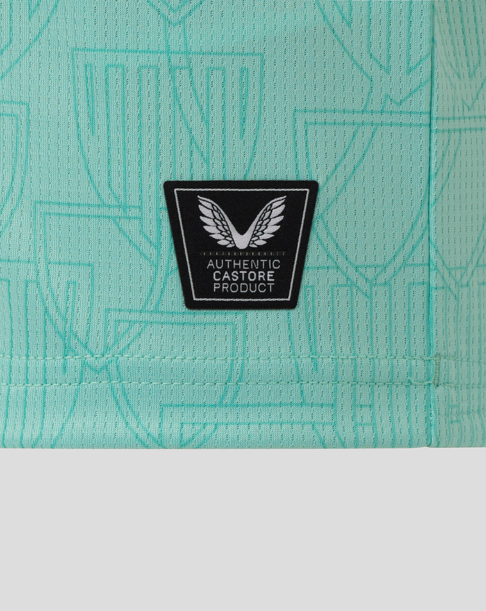 Close-up of black Castore authentic product patch on turquoise fabric.