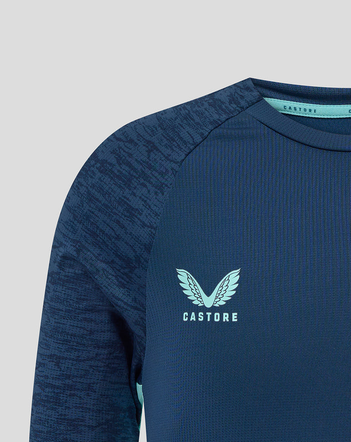 Front close-up of navy athletic club junior tee showing a light blue crest on the chest and Castore branding.