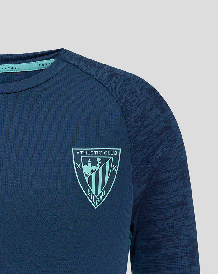 Navy athletic club junior tee close-up with crest on left chest and Castore logo on right.