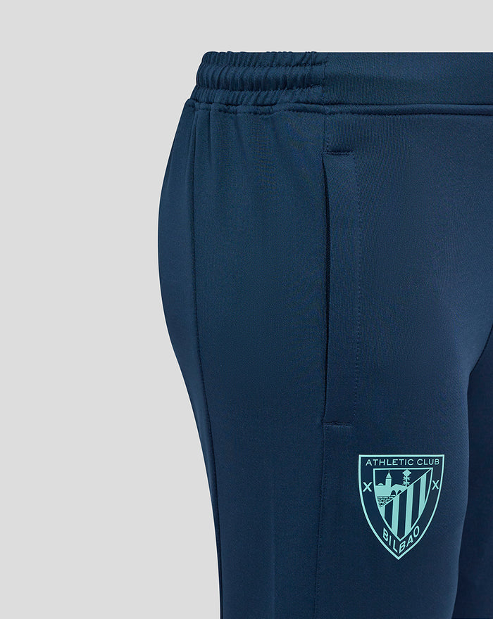 Close-up of navy training pants showing Athletic Club crest on the thigh with teal side panel detail