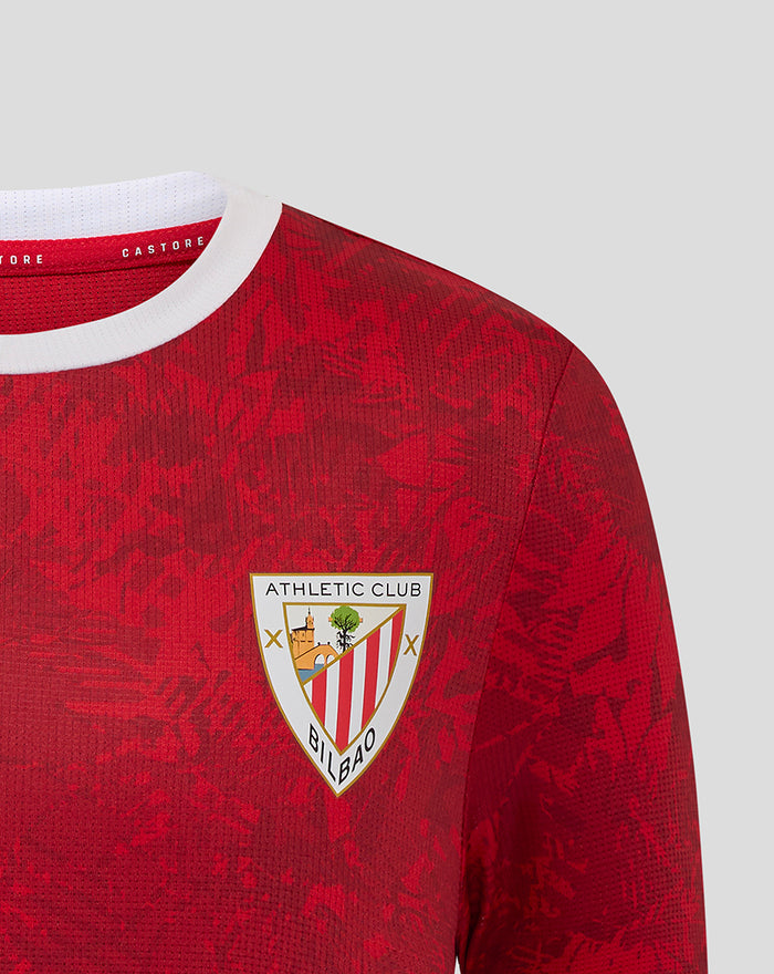 Close-up of left chest Athletic Club crest on the red patterned jersey with white collar.