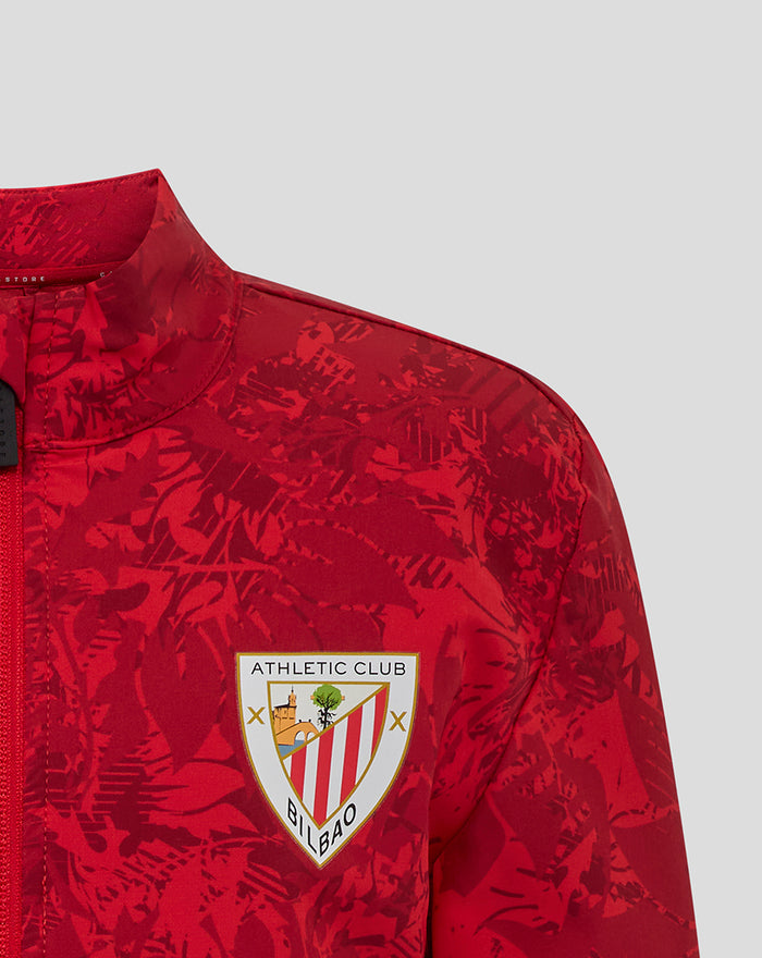 Close-up of the Athletic Club Bilbao crest on the chest of the red camo junior jacket