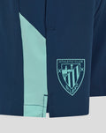 Navy junior woven shorts with a light turquoise side stripe and Athletic Club crest.