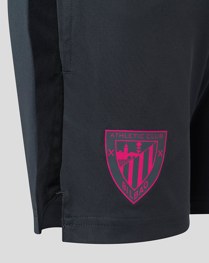 Close-up of navy shorts showing a bright pink Athletic Club crest on the left leg.