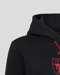 Detail of the black hoodie focusing on the hood and shoulder with red stitched accent near the neckline.