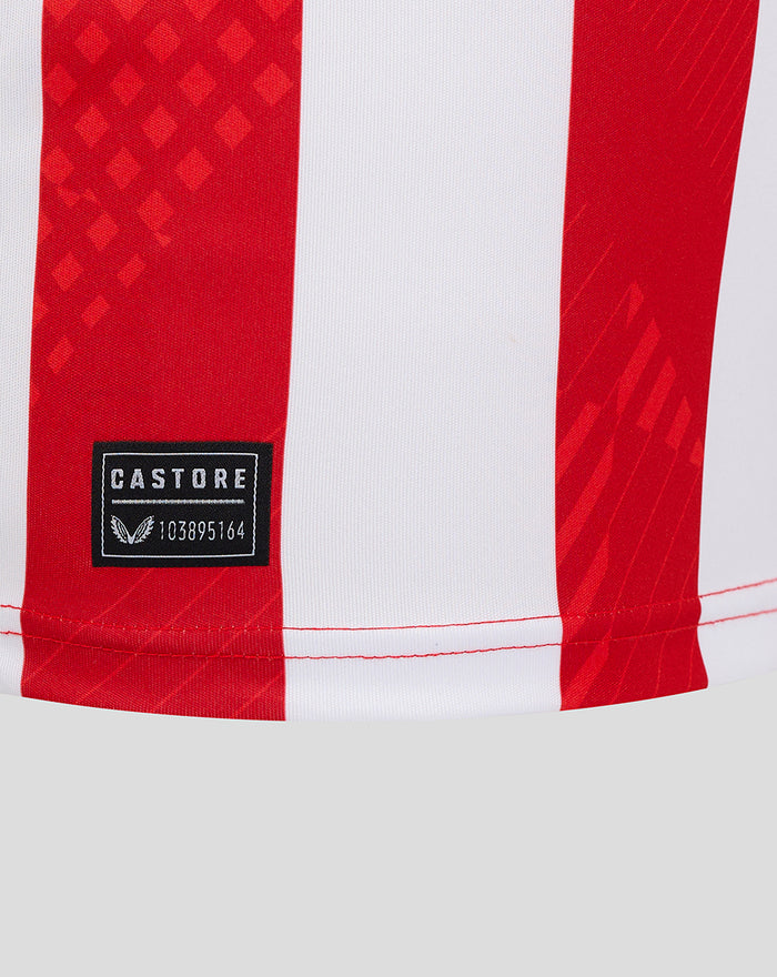 Lower shirt hem close-up with Castore patch and red stripe pattern.