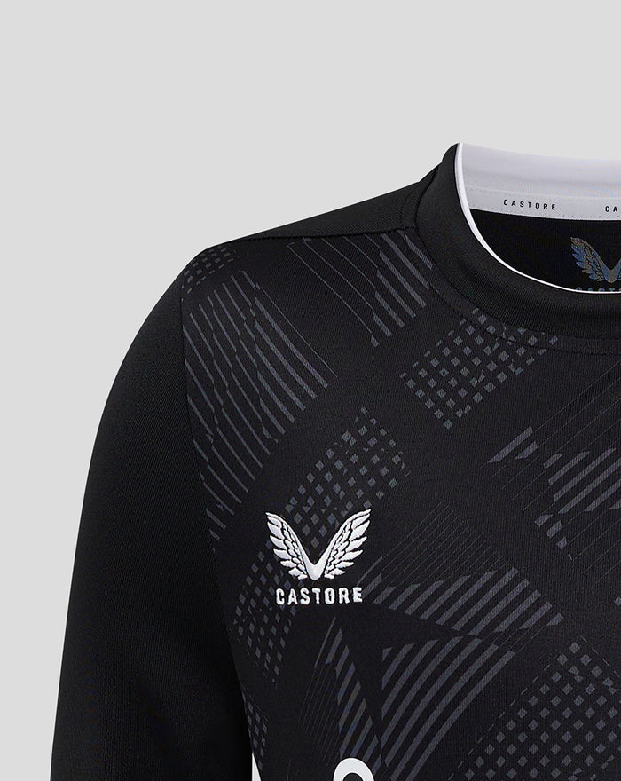 Close-up of black goalkeeper jersey with geometric pattern and Castore logo on the chest.