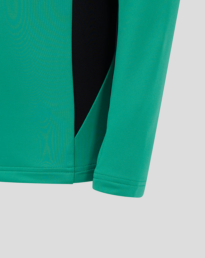 Teal green Junior Pro training top close up showing side vent and reinforced hem.
