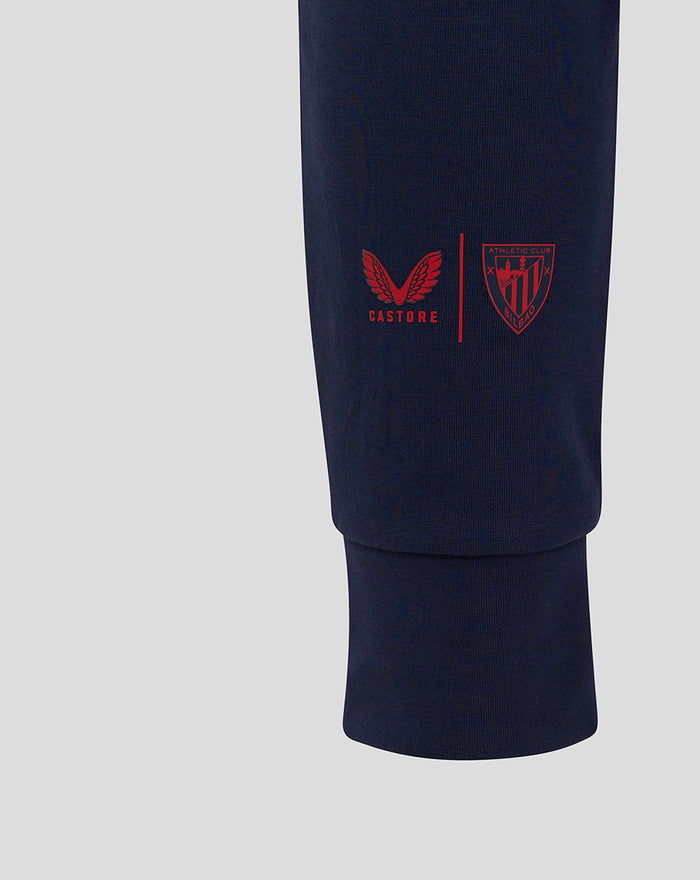 Navy junior travel pant leg showing Castore logo and Athletic Club crest in red