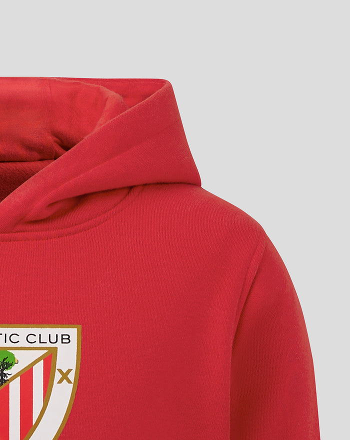Close-up of the red junior hoodie showing the hood and chest crest emblem
