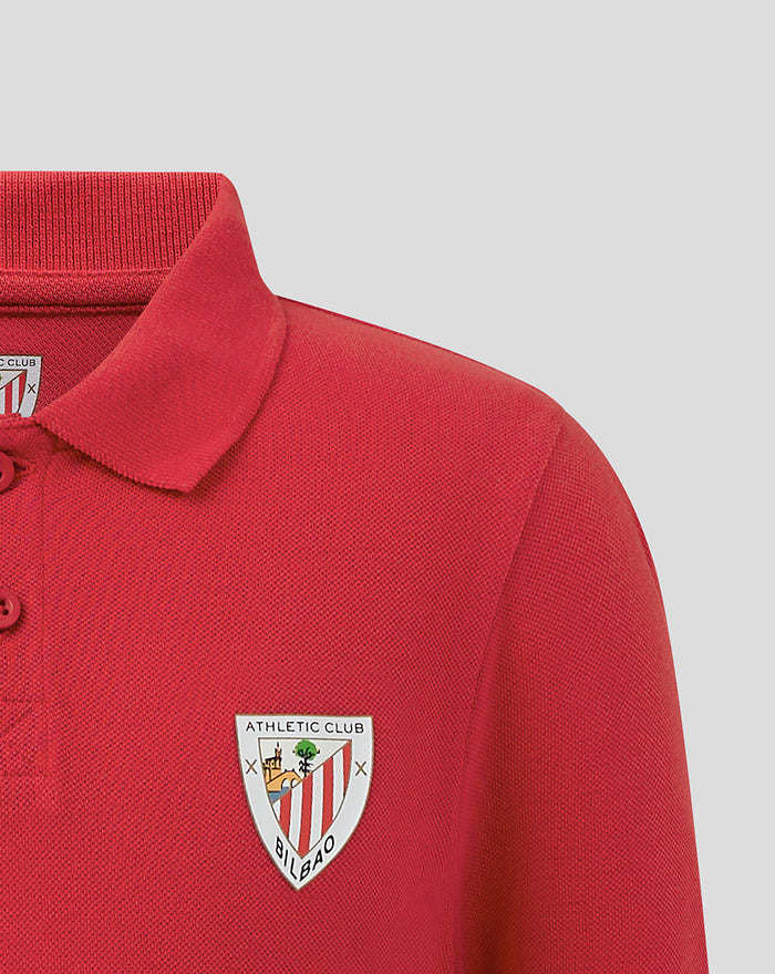 Close-up of red JUNIOR CORE POLO with left chest athletic club crest
