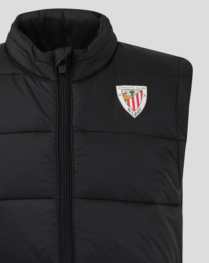 Close up of black padded gilet showing front zipper and left chest logo patch.