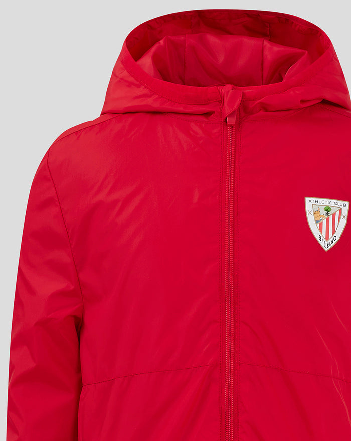 Front view of red Junior Core Summer Jacket with hood and crest logo on the chest