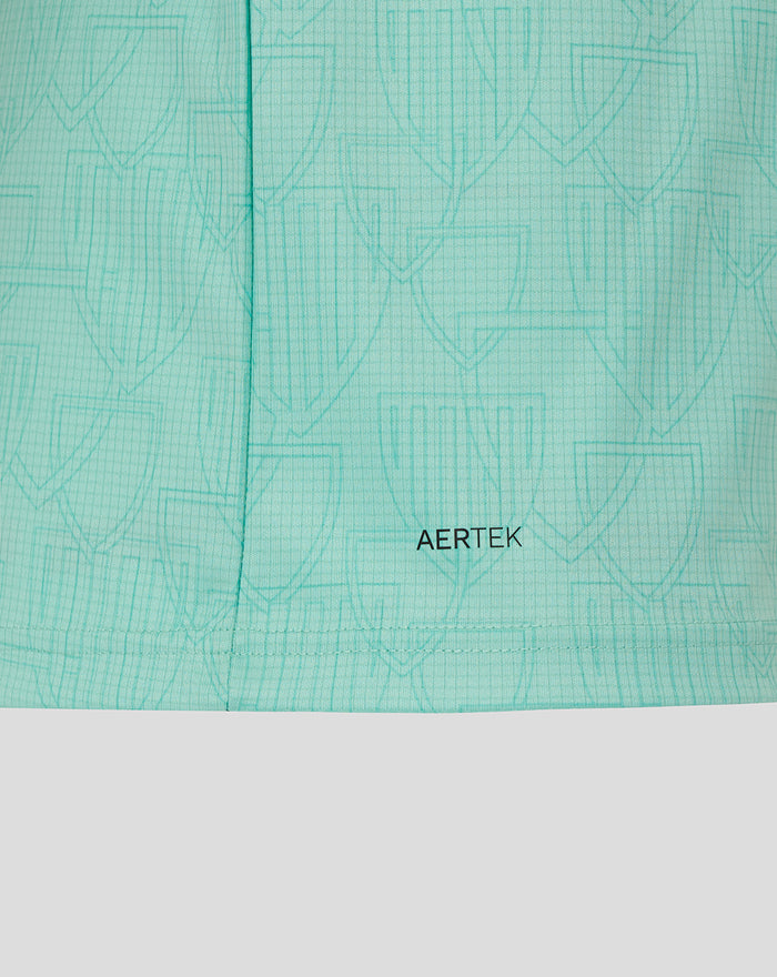 Close-up of mint green jersey fabric showing AerTek texture and a stitched hem with subtle embossed pattern.