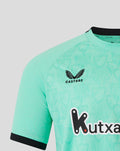 Close-up of mint green jersey showing Castore logo near the shoulder and Kutxabank across the chest.