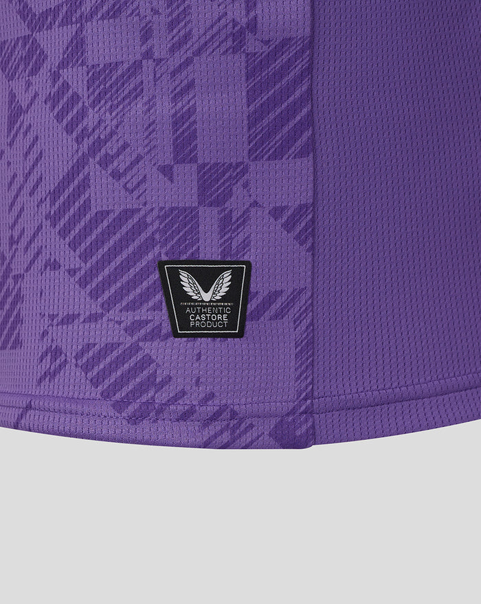 Lower front close up of purple goalkeeper jersey showing authentic Castore patch amid geometric print