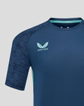 Close-up of navy athletic club performance tee chest area with Castore logo on right and club crest on left.