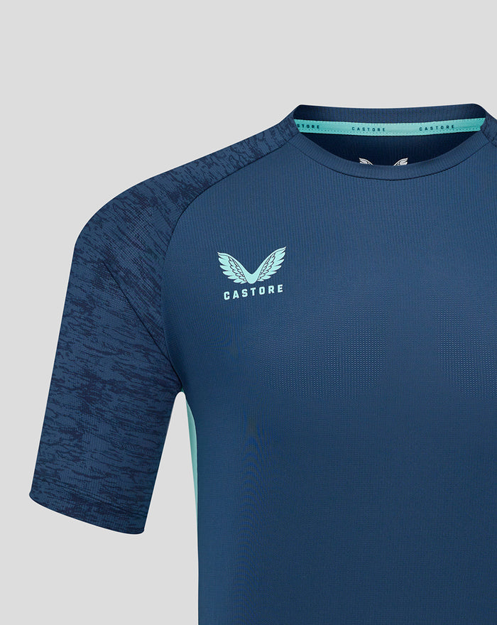 Close-up of navy athletic club performance tee chest area with Castore logo on right and club crest on left.