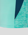 Close up of the shirt hem showing mint fabric with teal patterned side panel and a navy accent.