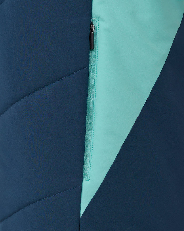 Close up of navy and turquoise color blocked athletic club gilet showing a vertical zipper pocket.