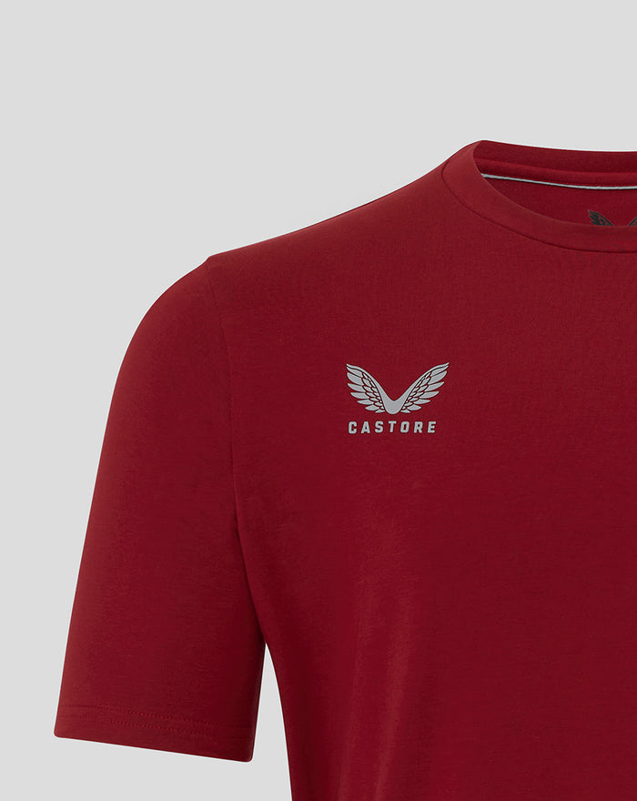 Close-up of chest showing Castore wing logo and branding on red Athletic Club Travel Tee.