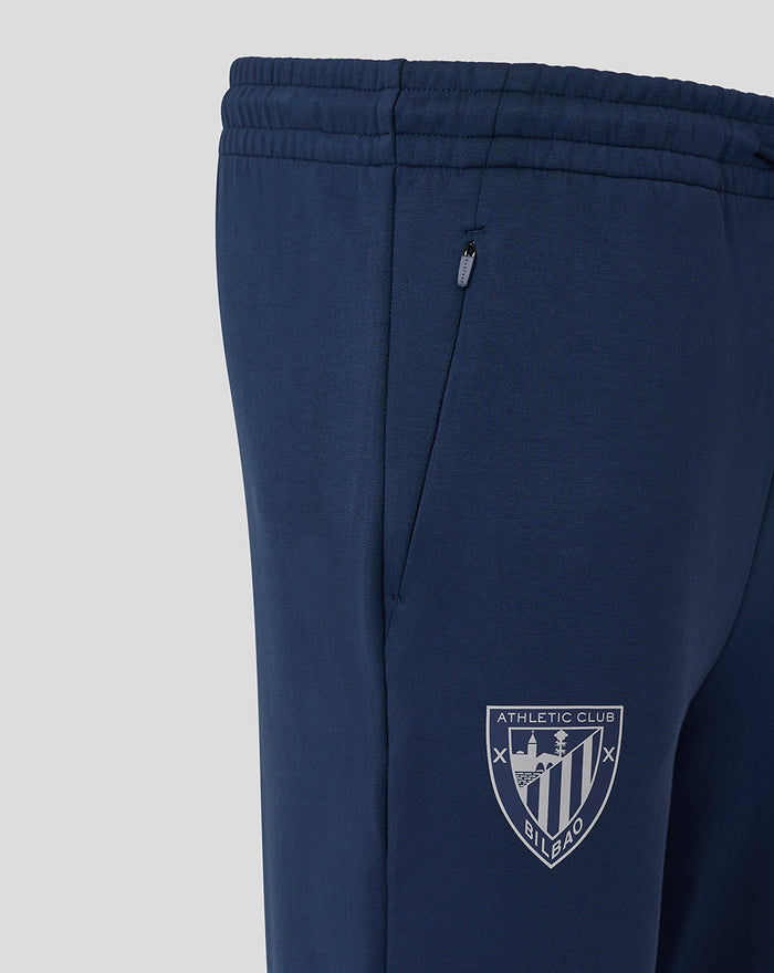 Navy Athletic Club travel knit pant shown in side view with a zip pocket and club crest on the lower leg