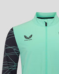 Close-up of mint green jacket front with zipper and crest on chest.
