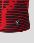 Close up of red and black striped junior shirt fabric with a small authenticity patch at the hem.
