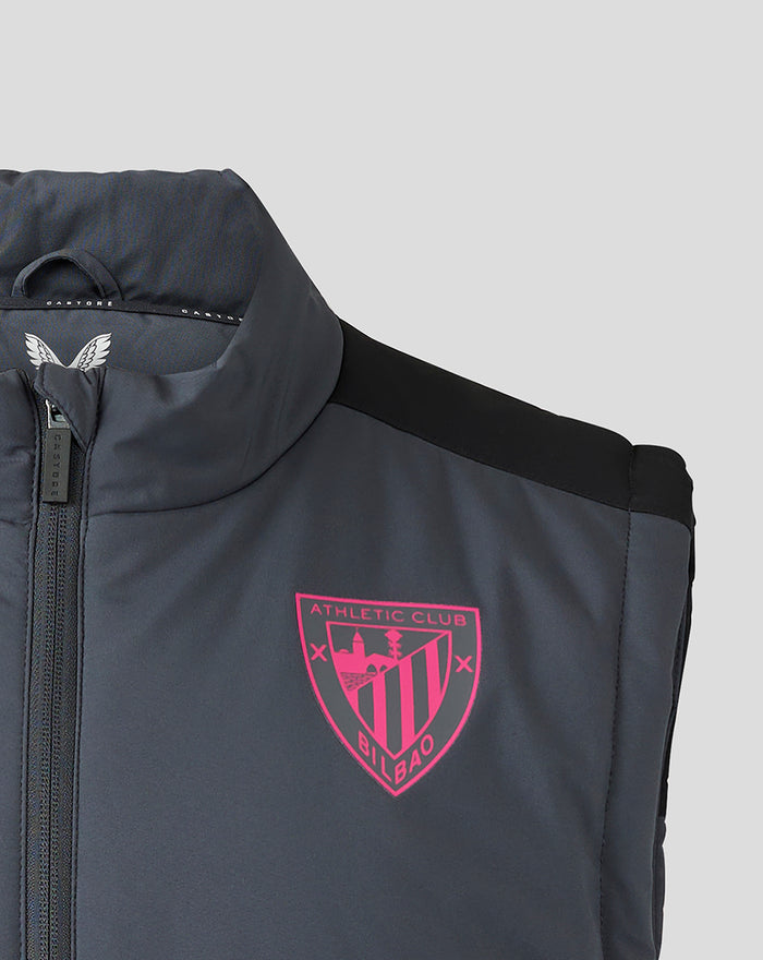 Close-up of chest area showing gray fabric, pink club crest, and zip detail on the gilet.