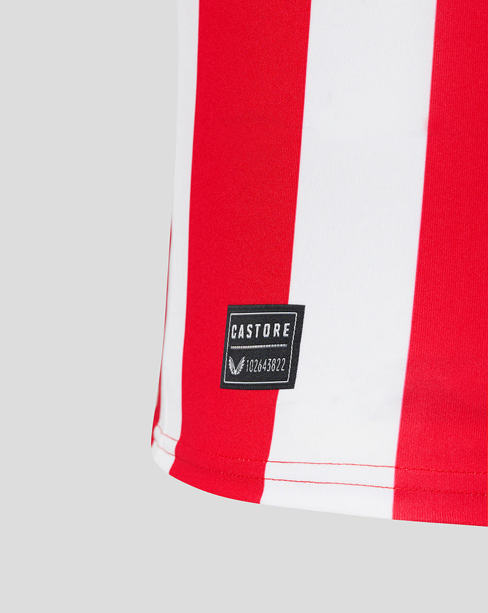 Hem close up of red and white striped jersey showing a Castore label stitched on the red stripe.