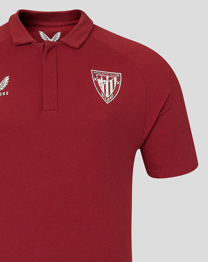 Close up of chest on a red polo showing Athletic Club Bilbao crest on the left and Castore logo on the right.