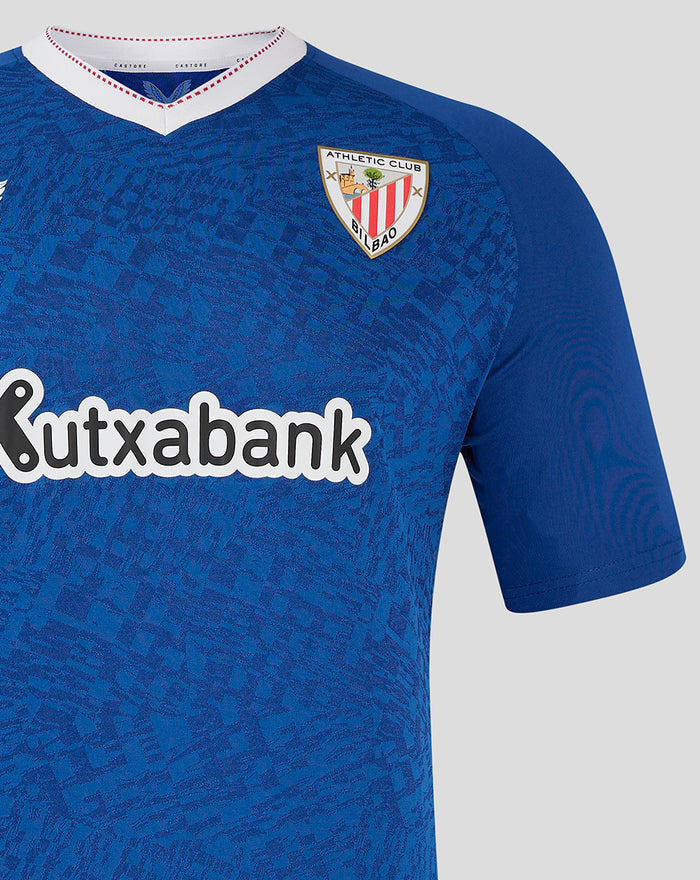 Close up of blue away shirt chest area showing the team crest and Kutxabank sponsor