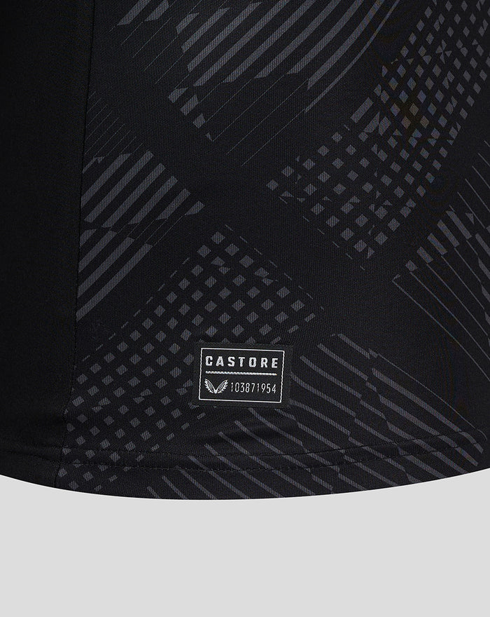 Close-up of dark geometric pattern on black goalkeeper jersey with Castore label near the hem.