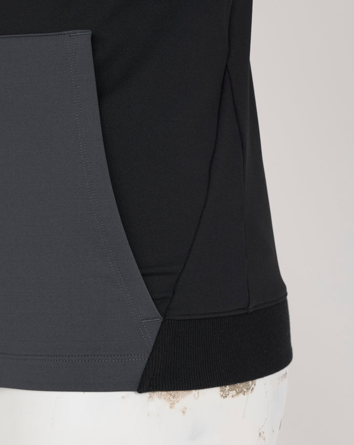 Close-up of grey pocket panel on black fleece hoodie with visible stitching