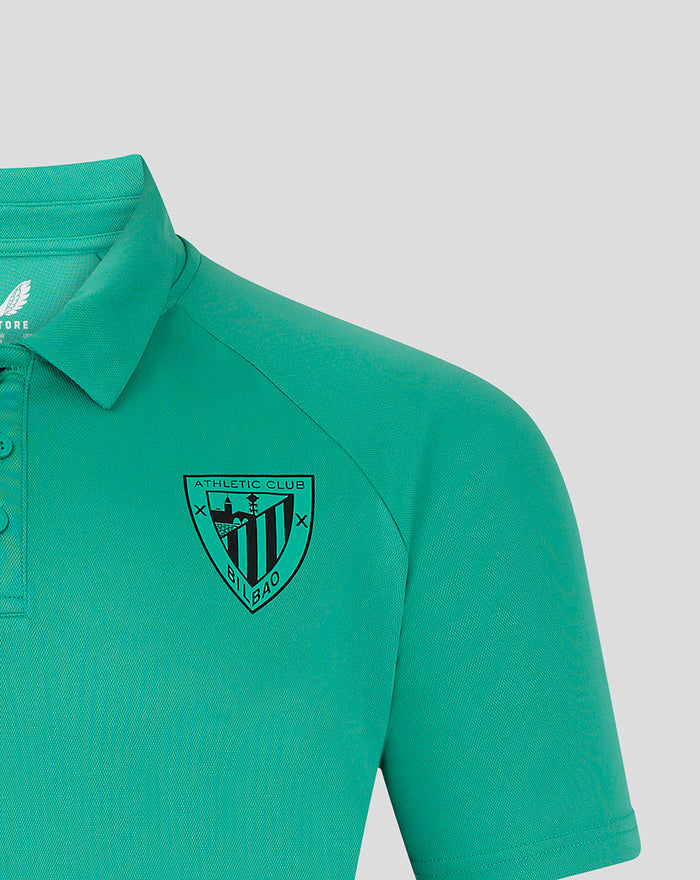Teal polo shirt close up highlighting crest badge on left chest and Castore branding near neckline