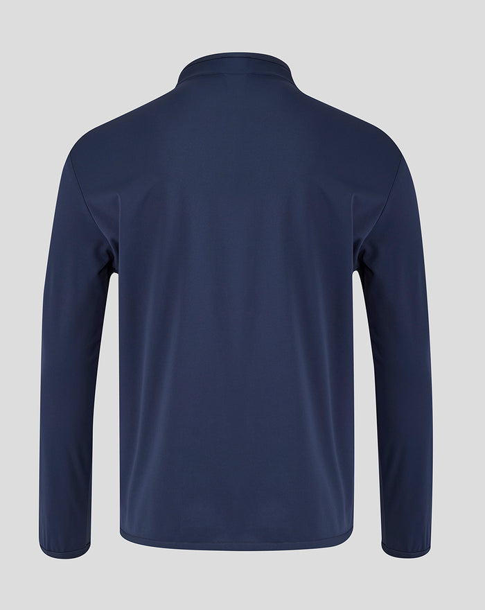 Back view of navy junior travel jacket with small red club crest on left sleeve.