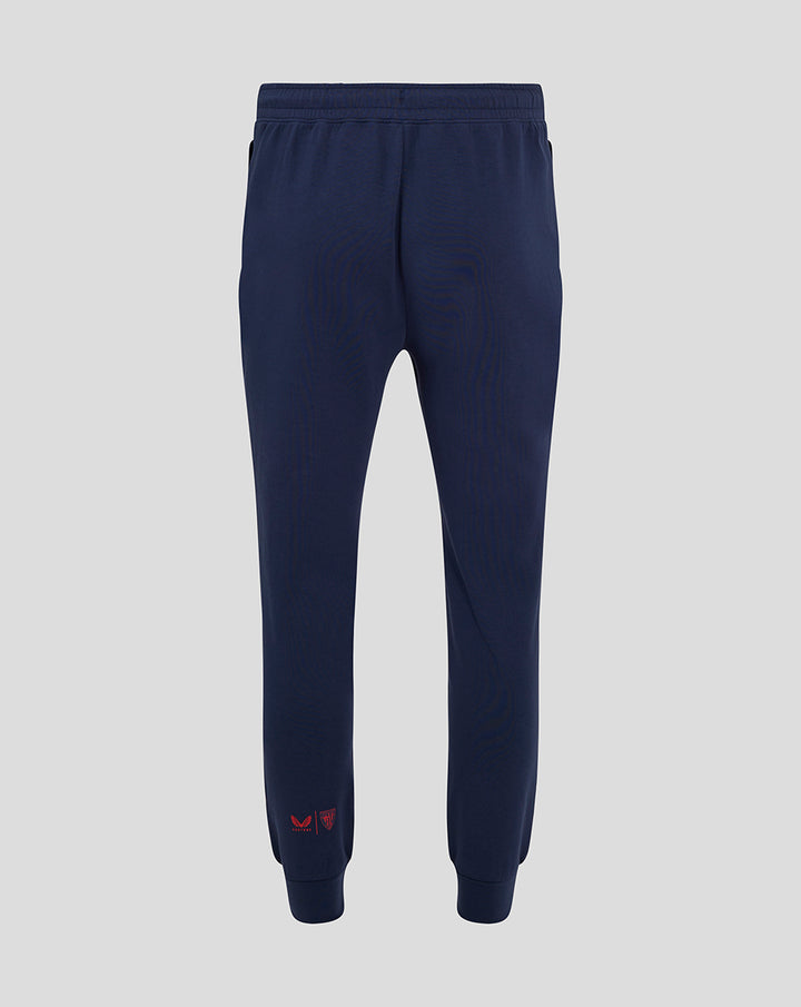 Back view of navy travel pants showing an elastic waistband and straight leg with cuff details
