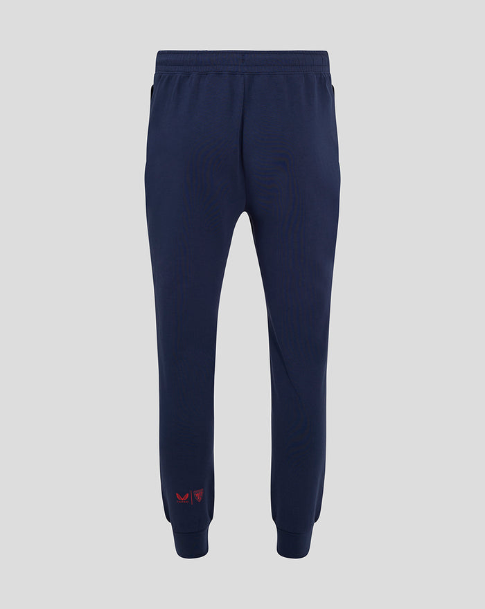 Back view of navy travel pants showing an elastic waistband and straight leg with cuff details