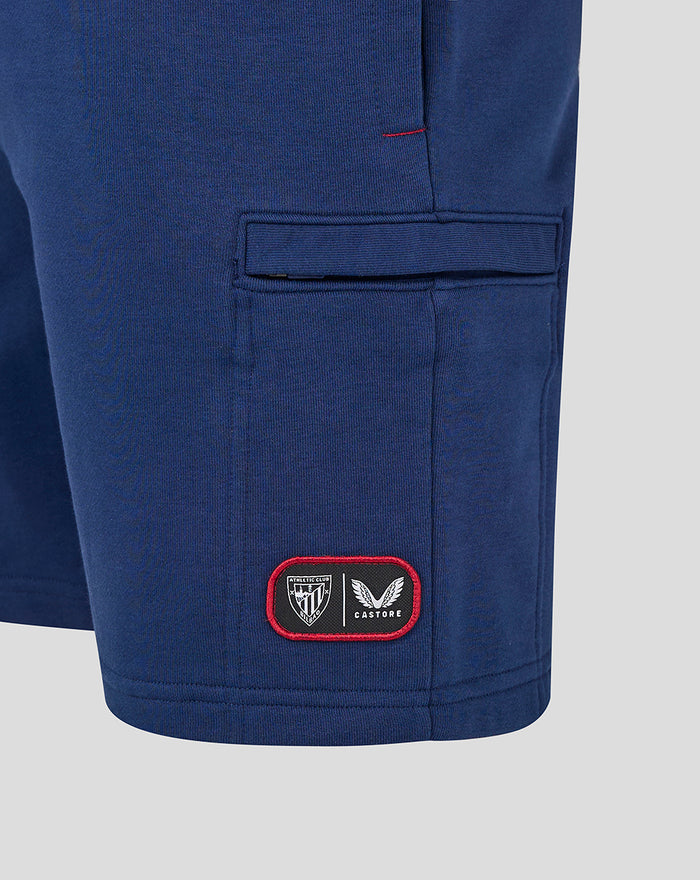 Blue athletic club shorts with a red-bordered patch logo near the hem.