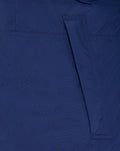 Back view of blue athletic jacket showing a diagonal pocket flap detail.