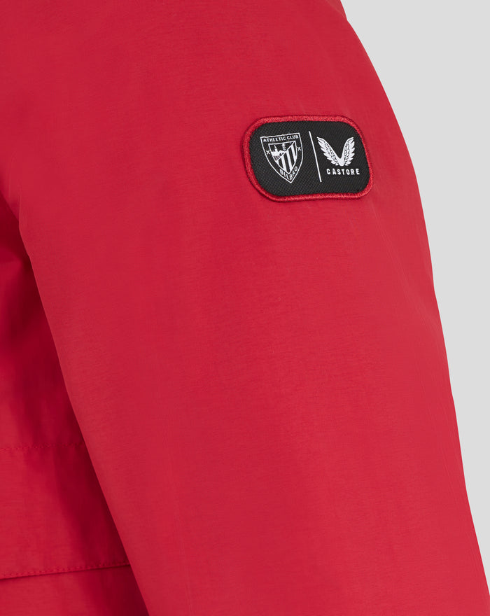 Small black patch with Athletic Club crest and Castore logo on red fabric