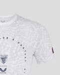 Close up of grey and white patterned tee with crest on the chest and a red patch on the sleeve