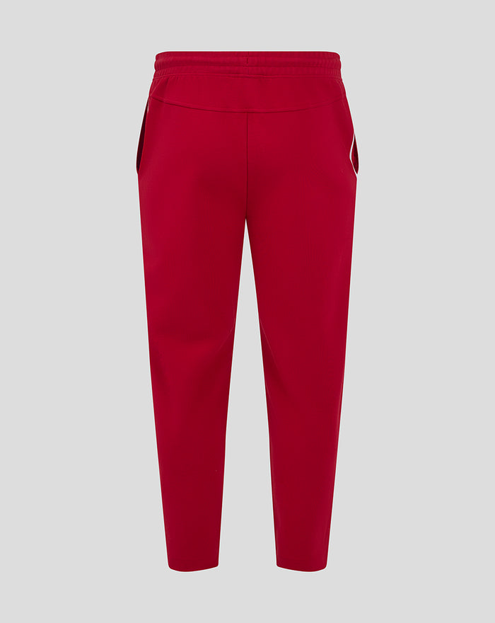Red athletic track pants with elastic waistband and white piping along the side