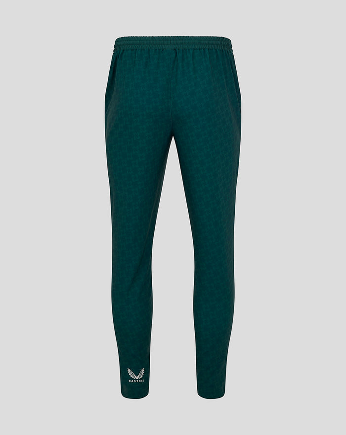 Mens dark green travel track pants with elastic waistband and tapered legs Castore logo at ankle.