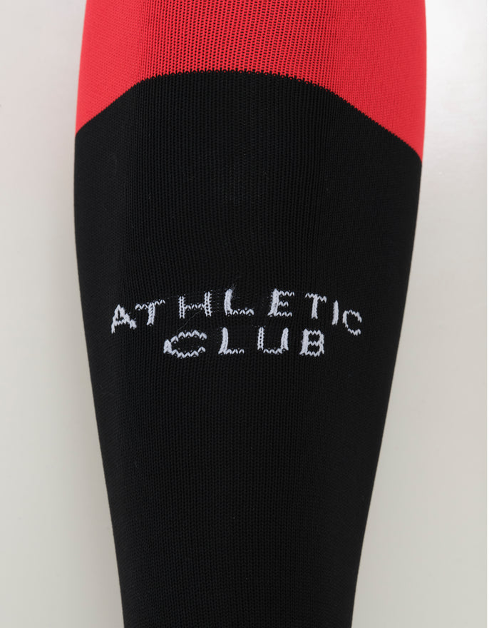 Close-up of Athletic Club Fourth Sock showing red top and black lower section with diagonal color transition.